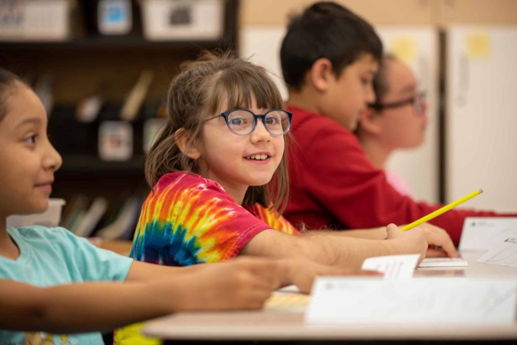 Alpine Elementary student smiles during financial literacy unit led by Silver Creek Leadership Academy students