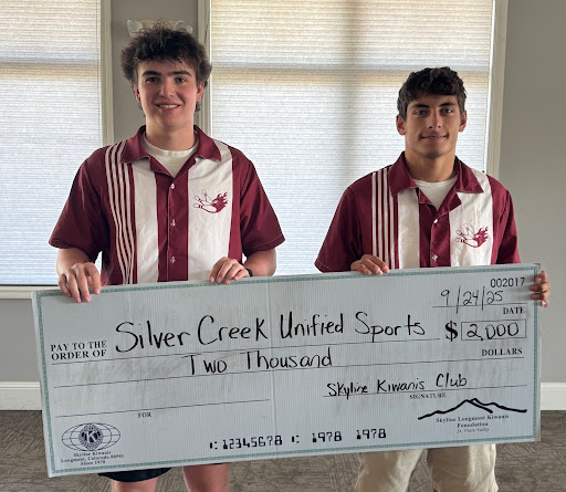 Two students hold a large check for $2,000 made out to Silver Creek Unified Sports.